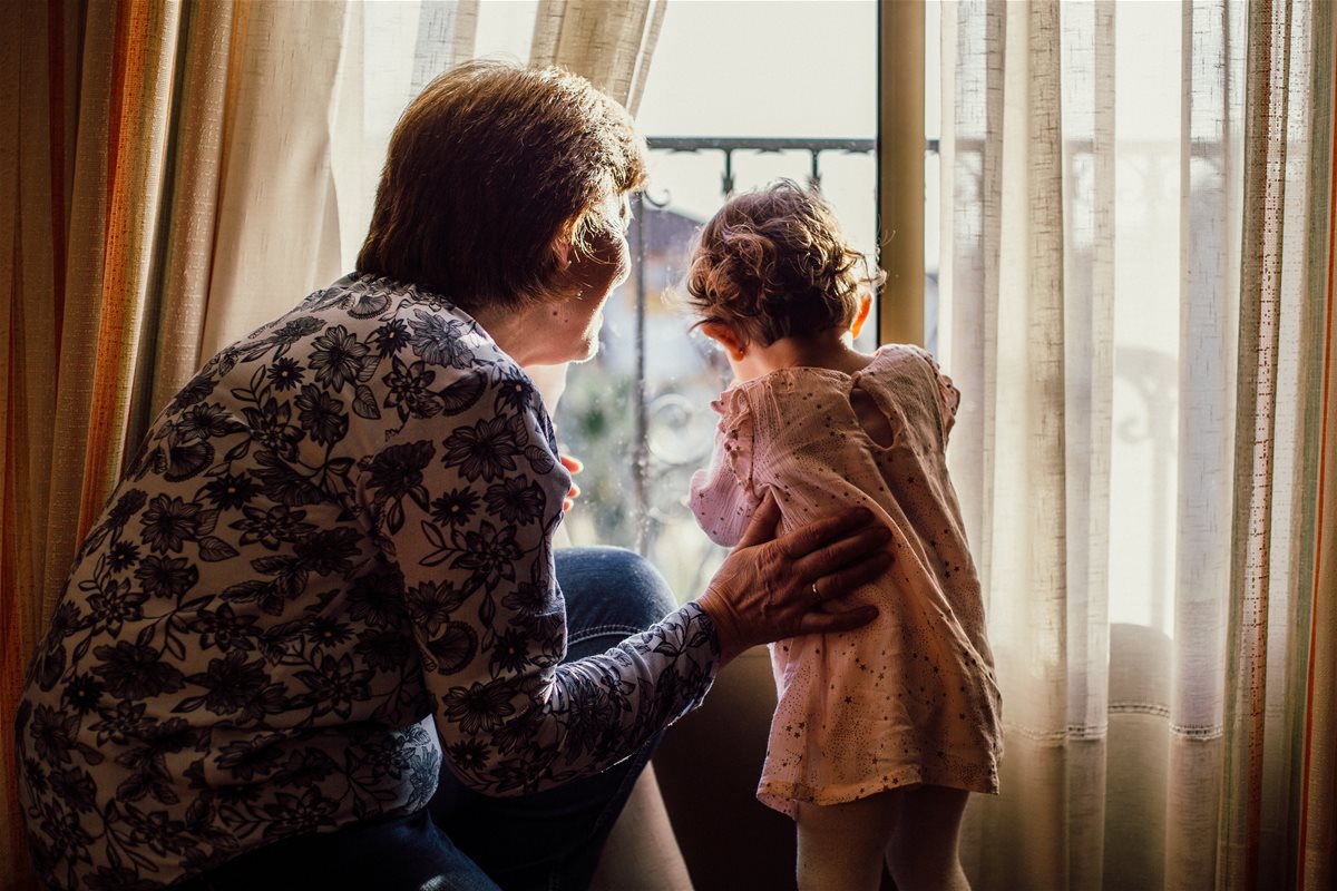 canva---woman-holding-baby-near-window